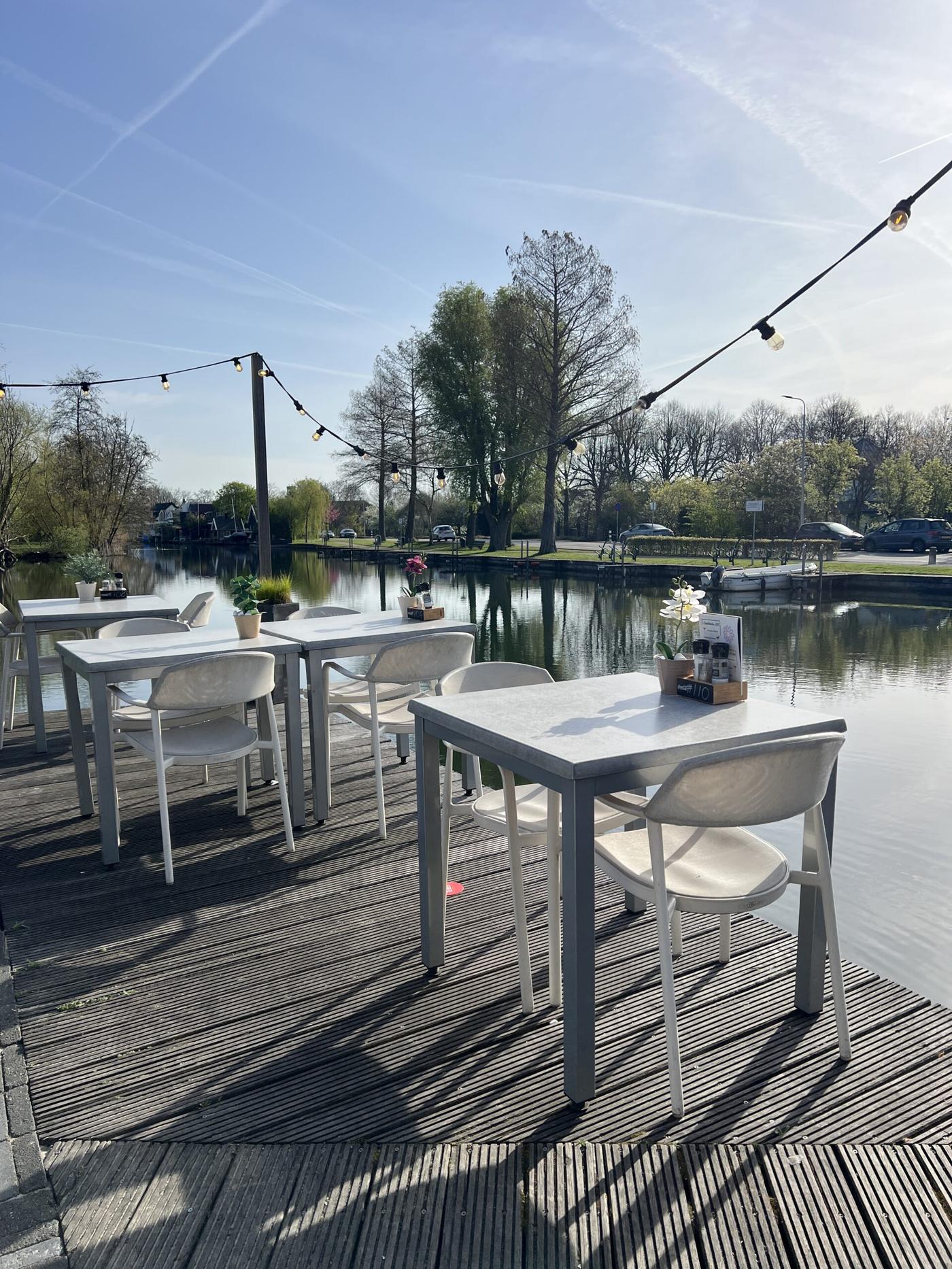 Het terras aan het water met lichtslingers